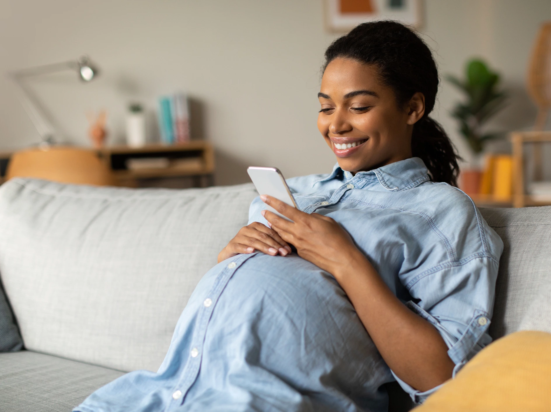 Pregnant mom smiling while using the WIN app