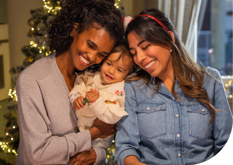 Two women hugging a baby