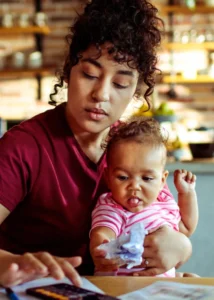 Image description Mom holding child while looking at employee options